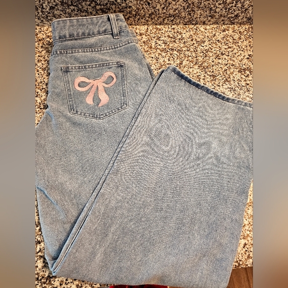 Fashion Nova Denim - Stylish Blue Jeans with Pink Bow Accent.